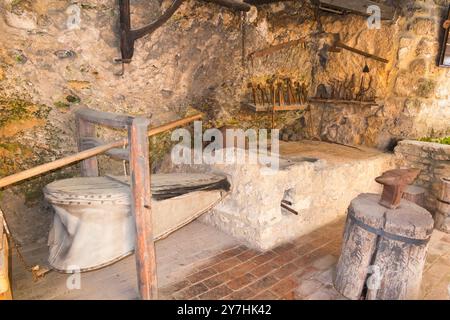 Ausstellung für Touristen mit traditionellem Werkzeug und Ofen, unterstützt von Luftbälgen in der Black Smiths Werkstatt im Krka Nationalpark. Kroatien. (138) Stockfoto