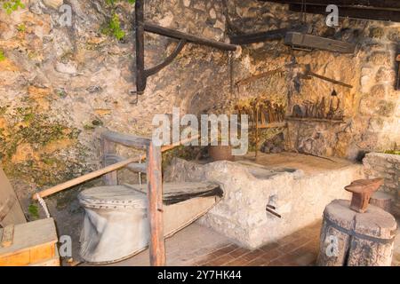 Ausstellung für Touristen mit traditionellem Werkzeug und Ofen, unterstützt von Luftbälgen in der Black Smiths Werkstatt im Krka Nationalpark. Kroatien. (138) Stockfoto