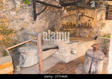 Ausstellung für Touristen mit traditionellem Werkzeug und Ofen, unterstützt von Luftbälgen in der Black Smiths Werkstatt im Krka Nationalpark. Kroatien. (138) Stockfoto