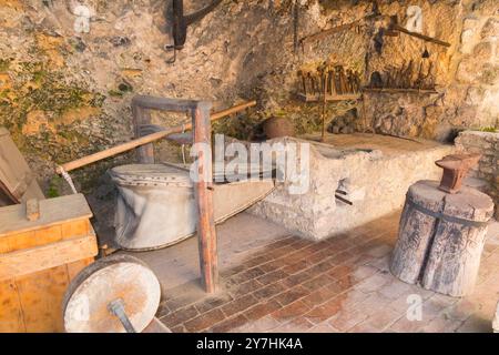 Ausstellung für Touristen mit traditionellem Werkzeug und Ofen, unterstützt von Luftbälgen in der Black Smiths Werkstatt im Krka Nationalpark. Kroatien. (138) Stockfoto