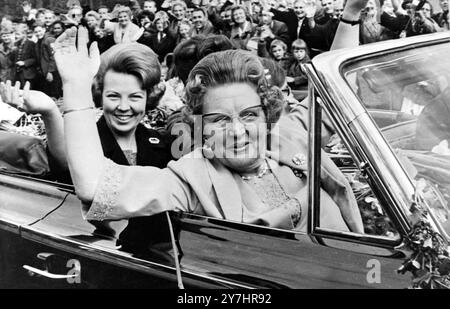 30. APRIL 1964 KÖNIGIN JULIANA FEIERT IHREN 55. GEBURTSTAG UND WINKT WELLWISHERS WÄHREND EINER FAHRT MIT DER FAMILIE IN AMSTERDAM, NIEDERLANDE. Stockfoto