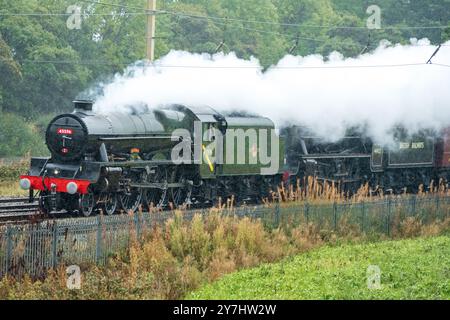 Dampflokomotiven Bahamas und Stanier Black Five Nummer 44392. Fahren Sie bei starkem Regen auf der West Coast Main Line in Winwick nach Norden. Stockfoto