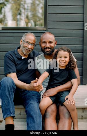 Porträt eines älteren Mannes, der mit Sohn und Enkel auf der Veranda sitzt Stockfoto