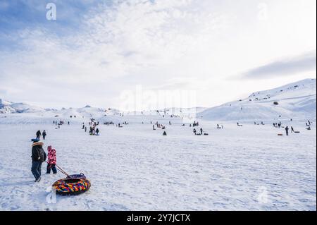 Die Menschen entspannen sich und Rollen die Rutsche auf Tubing im Winter in der Natur in den Bergen Kasachstans herunter. Shymkent, Kasachstan - 27. Januar 2024 Stockfoto