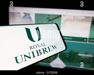 Handy mit Logo der dänischen Brauerei Royal Unibrew auf dem Bildschirm vor der Business-Website. Fokussieren Sie sich auf die linke Mitte des Telefondisplays. Stockfoto