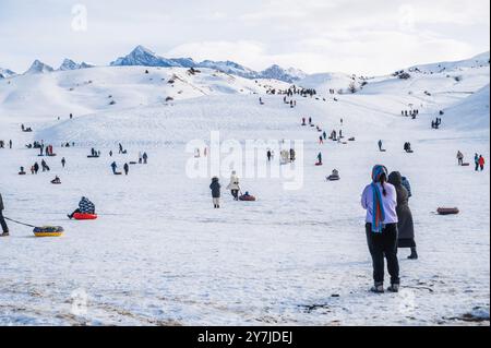 Die Menschen entspannen sich und Rollen die Rutsche auf Tubing im Winter in der Natur in den Bergen Kasachstans herunter. Shymkent, Kasachstan - 27. Januar 2024 Stockfoto