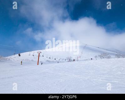 Skifahrer auf der Piste und Sessellifte (Grand Hirafu, Niseko) Stockfoto