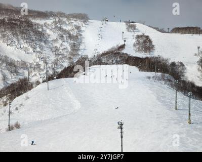 Skifahrer auf der Piste und Sessellifte (Grand Hirafu, Niseko) Stockfoto