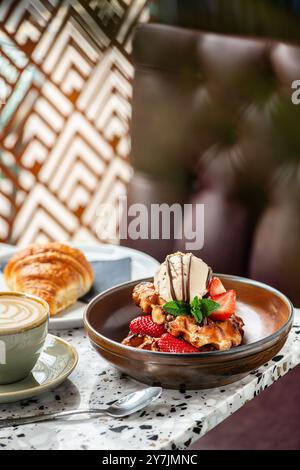 Amerikanische Waffeln mit Eis, Erdbeeren, Ahornsirup und Zartbitterschokolade. Stockfoto