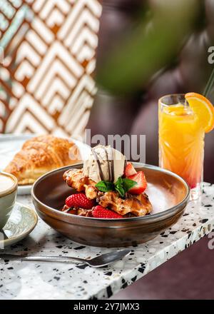 Amerikanische Waffeln mit Eis, Erdbeeren, Ahornsirup und Zartbitterschokolade. Stockfoto