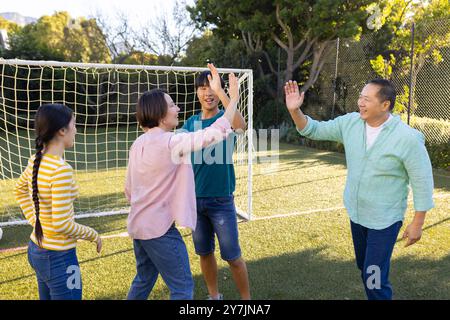 Gemeinsam feiern, mit der Familie auf dem Fußballfeld im Freien High Fives geben Stockfoto