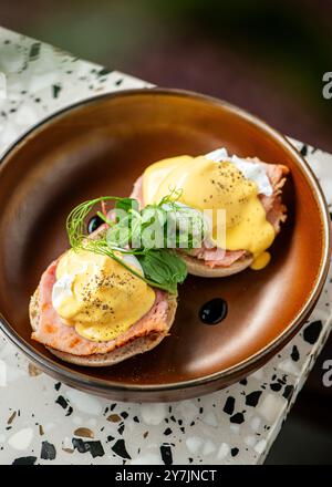 Pochierte Eier und Toast mit Schinken und Salat darauf. Stockfoto