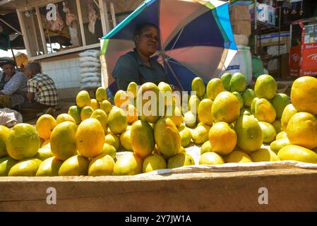 Eine Frau, die Mangos auf dem Kalerwe-Markt verkauft, Kampala Uganda Stockfoto