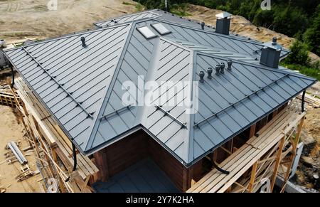 Luftaufnahme des Retro-Dachblechs des Hauses mit Stehnaht, Verschluss. Modernes verzinktes Stahlblech mit Rippen. Graue Metallplatte im klassischen Stil Stockfoto