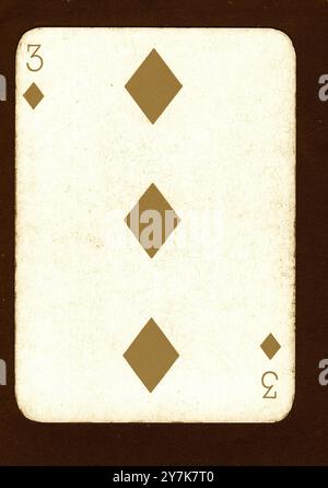 Eine Vintage drei Diamanten-Spielkarte in Sepia auf schwarzem Hintergrund. Stockfoto