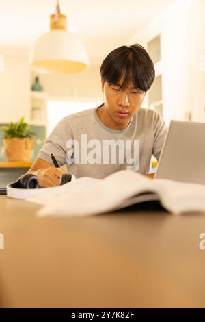 Studieren, junger Mann mit Laptop und Schreiben im Notizbuch Stockfoto