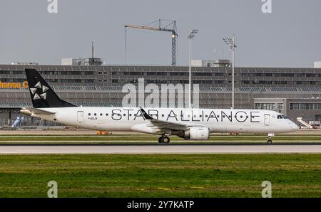 München, 8. April 2024: Ein Embraer 190AR von Air Dolomiti Taxis zur Start- und Landebahn am Flughafen München. Das Flugzeug trägt die Star Alliance-Lackierung. Re Stockfoto