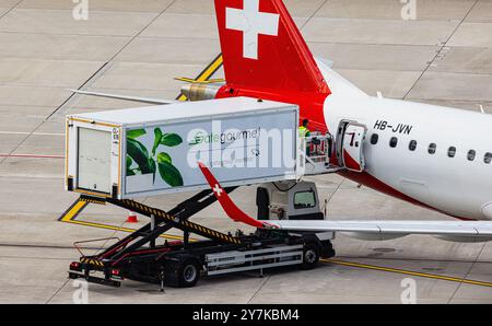 Zürich, Schweiz, 5. Mai 2024: Ein Gategourmet-Fahrzeug liefert Lebensmittel an einen Helvetic Airways Embraer 190LR am Flughafen Zürich. Registrierung der Klimaanlage Stockfoto