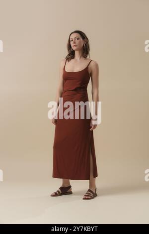 Serie von Atelierfotos eines jungen weiblichen Models in braunem Baumwoll-Camisole-Kleid. Klassische und einfache Sommermode. Stockfoto