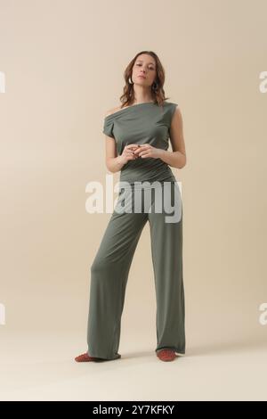 Weibliches Model trägt Loungewear-Outfit aus weicher Baumwolle, grünes Oberteil und Hose. Klassische und einfache Mode. Studio-Aufnahme. Stockfoto