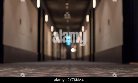 Hotelflur mit selektivem Fokus auf Teppich und verschwommenem Hintergrund. Stockfoto