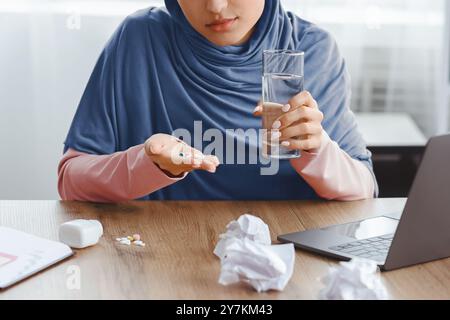 Depressive Muslimische Frau, Die Drogen Am Arbeitsplatz Im Büro Nimmt Stockfoto