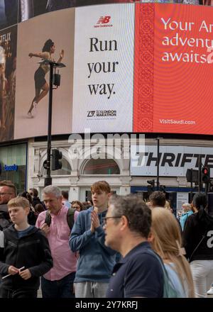 London, England, April 30 2023: London, England, April 30 2023: Leute warten auf die Überquerung der Straße im Piccadilly Circus, an einem geschäftigen Nachmittag mit dem großen SC Stockfoto