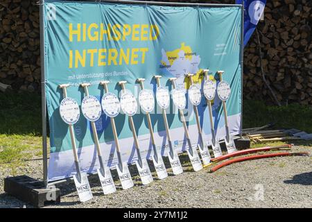 Werbebanner für Hochgeschwindigkeits-Internet mit aufgereihten Schaufeln und Holzstapeln im Hintergrund, Glasfaserinstallation, Neukirch, Deutschland, EUR Stockfoto