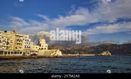 Morgenlicht, Eine wunderschöne Küstenstadt mit Hafen und Bergen im Hintergrund, Pigadia, Stadt und Hafen, Pigadia Bay, Hauptstadt, Karpathos, Do Stockfoto