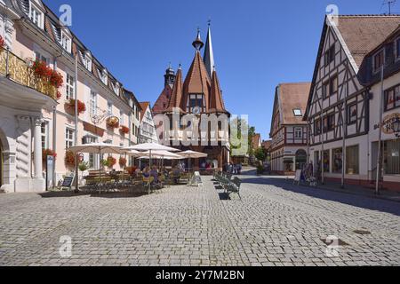 Historisches Rathaus mit Außenbereich des Süßwarengeschäfts und Café Leyhausen unter wolkenlosem blauem Himmel auf dem Marktplatz in Michelstadt, Odenwald Stockfoto