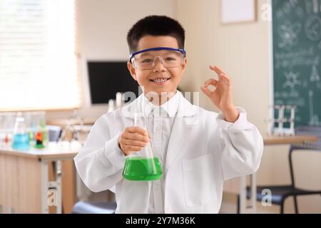 Süßer kleiner Junge mit Chemiekolben, der im Wissenschaftsunterricht OK ist Stockfoto