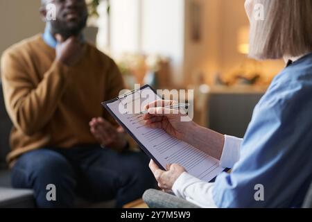 Großaufnahme der Ärztin, die die medizinische Karte ausfüllt Stockfoto