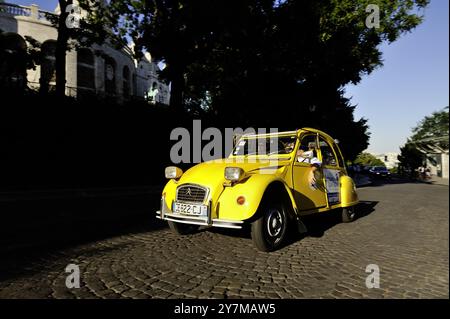 FRANKREICH, PARIS (75) STADTRUNDFAHRT IM 18. ARRONDISSEMENT MIT 2CV QUATRE ROUES SOUS UN PARAPLUIE, HALT AM MONTMARTRE, ENGLISCHE TOURISTEN Stockfoto