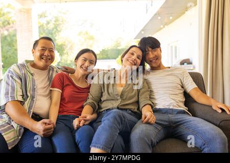 Lächelnde kleine Familie, die auf der Couch sitzt und eine gute gemeinsame Zeit genießt Stockfoto