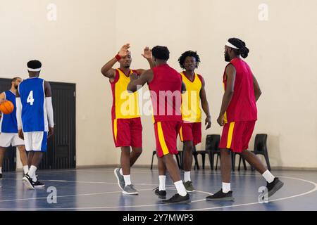 Basketball in der Schule spielen, Team feiert erfolgreiches Spiel, trägt Uniformen Stockfoto