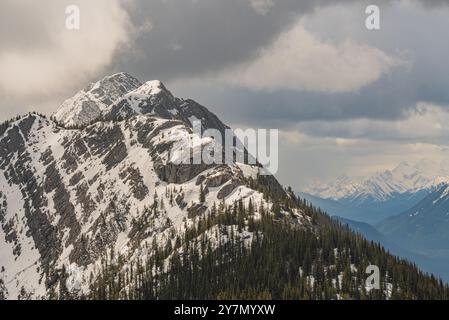 Atemberaubende Berggipfel von der Spitze der Banff-Gondel im Frühling mit schneebedeckten Bergen rund um den Alpengipfel. Stockfoto