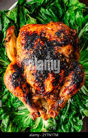 Vietnamesisches gebratenes Huhn auf einem Bett mit Sauteed Bok Choy: Goldbraunes, glasiertes Hähnchen auf einer Platte, die mit verwelktem Bok Choy bedeckt ist Stockfoto