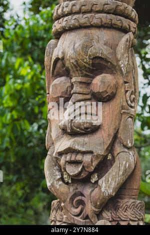 Balikpapan, Indonesien - 29. September 2024. Eine Nahaufnahme eines verwitterten Dayak-Stammes aus Holz mit einem detaillierten geschnitzten Gesicht mit großen Augen A Stockfoto