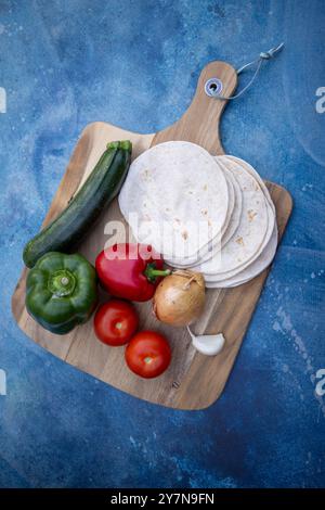 Ein lebendiges und farbenfrohes Sortiment an frischem Gemüse gepaart mit Tortillas, ideal für gesunde Mahlzeiten Stockfoto
