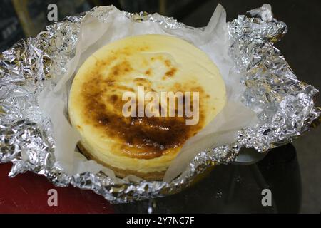 Classic Plain No Bake Cheesecake in einem Graham Cracker Crust Konditor glättet die Käsebasis des Käsekuchen mit einem Silikonspachtel. Stockfoto