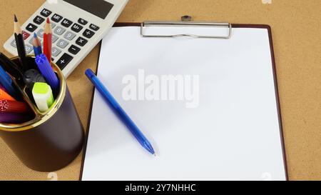 Leere Seite auf dem Schreibtisch mit Schreibwaren und Taschenrechner. Stockfoto