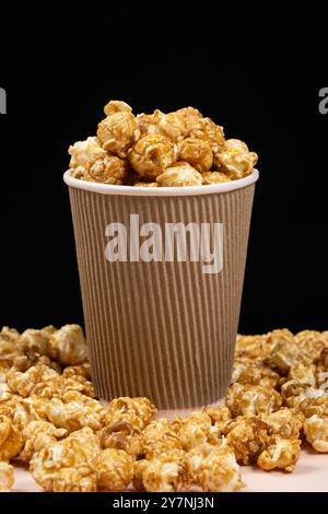 Süßes karamelisiertes Popcorn in einem Eimer. Schwarzer Hintergrund Stockfoto