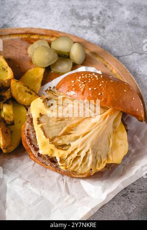 Hamburger mit Austernpilzen und Cheddar auf einem Holzschneidebrett Stockfoto