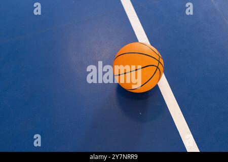 Basketball auf dem Platz, auf blauem Boden nahe der weißen Linie, Kopierraum Stockfoto