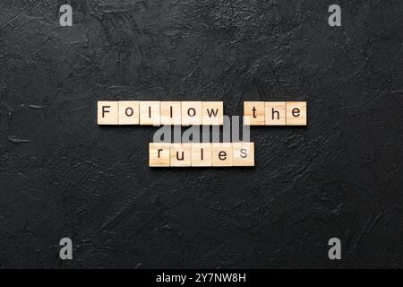 Die Regeln Wort auf Holz Block geschrieben. Die Regeln Text in Tabelle folgen, Konzept. Stockfoto