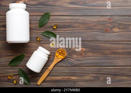 Omega-3 Kapseln liegen in einer weißen Flasche auf einem Tisch mit grünem Blatthintergrund. Fischöltabletten. Biologisch aktive Zusatzstoffe. omega 6, Omega 9, Vitam Stockfoto