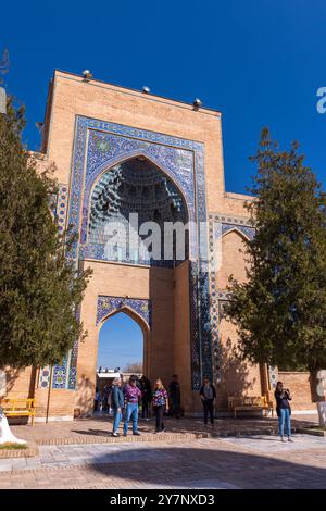 Samarkand, Usbekistan - 25. März 2024: Touristen befinden sich in der Nähe des Eingangsportals des Mausoleums Gur-e Amir des turkomongolischen Eroberers Timur Stockfoto