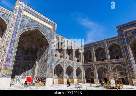 Samarkand, Usbekistan - 25. März 2024: Touristen besuchen die Sher-dor Madrasah auf dem Registan-Platz an einem sonnigen Tag Stockfoto