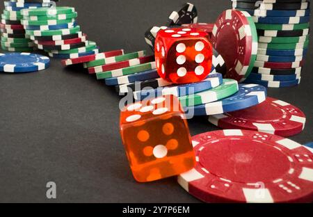 Rote Würfel auf dem Casino-Tisch mit Poker-Chips auf dem Hintergrund Stockfoto