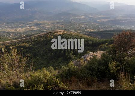 Dramatisches Stadtpanorama mit Blick auf grüne Hügel Stockfoto